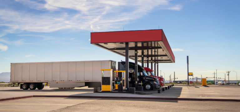 Commercial truck fueling at a truck stop as fuel costs continue to impact trucking company profitability.